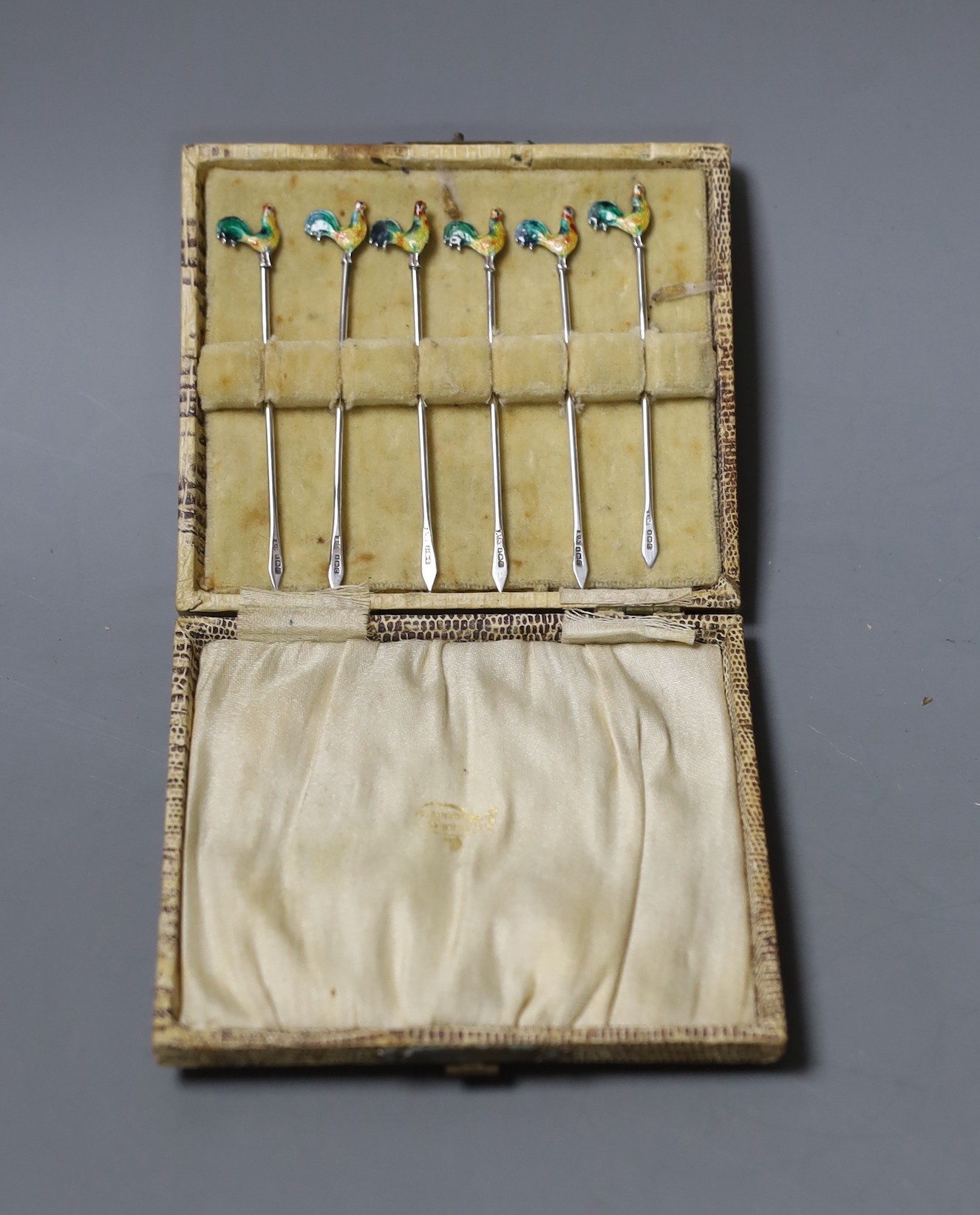 A cased set of six George V silver and enamel ‘Cockerel’ terminal cocktail sticks, Birmingham, 1927.